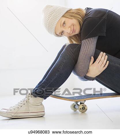 Portrait of young woman sitting on skateboard View Large Photo Image Stock Image - Portrait of young woman sitting on skateboard. Fotosearch