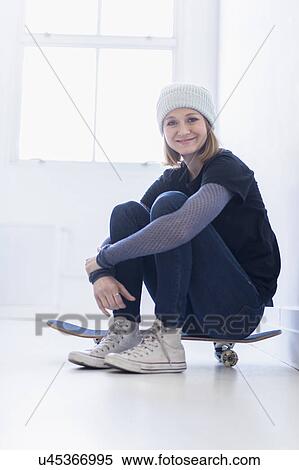 Portrait of young woman sitting on skateboard View Large Photo Image Stock Photography - Portrait of young woman sitting on skateboard. Fotosearch