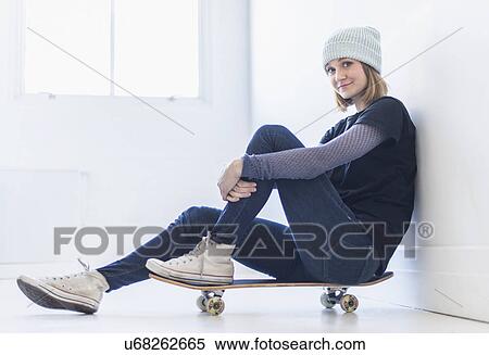 Portrait of young woman sitting on skateboard View Large Photo Image Stock Photography - Portrait of young woman sitting on skateboard. Fotosearch