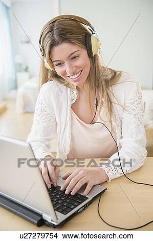 Picture - Portrait of young woman using laptop. Fotosearch