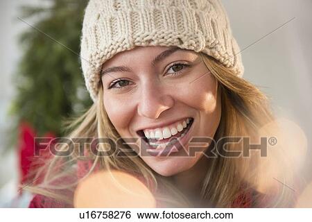 Stock Photograph - Portrait of young woman wearing knit hat. Fotosearch