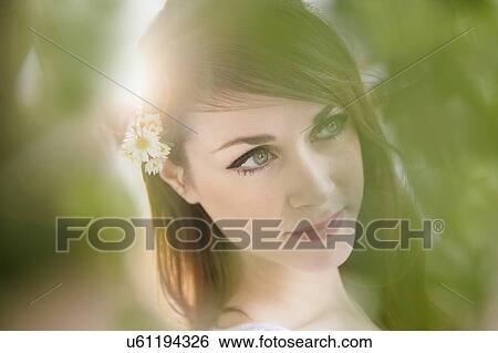 Stock Photograph - Portrait of young woman with daisies in hair. Fotosearch