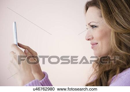Profile of woman holding digital tablet View Large Photo Image Stock Image - Profile of woman holding digital tablet. Fotosearch