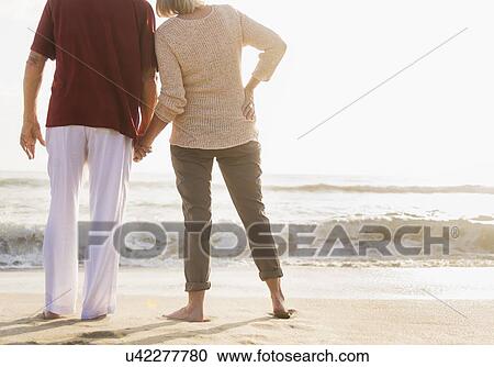 Rear view of senior couple holding hands View Large Photo Image Stock Image - Rear view of senior couple holding hands. Fotosearch