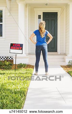Rear view of woman standing next to for rent sign View Large Photo Image Stock Image - Rear view of woman standing next to for rent sign. Fotosearch