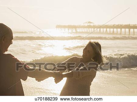 Stock Photo - Senior couple dancing on beach. Fotosearch