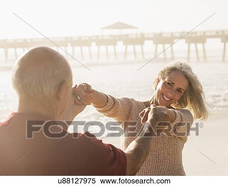 Stock Photography - Senior couple dancing on beach. Fotosearch