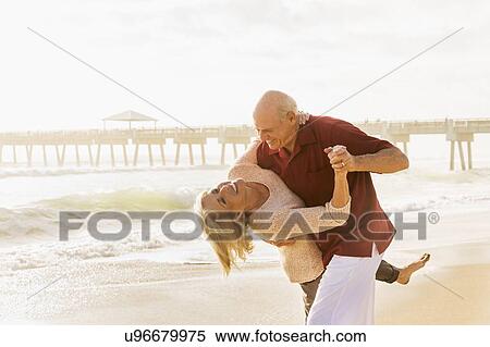 Stock Photography - Senior couple dancing on beach. Fotosearch