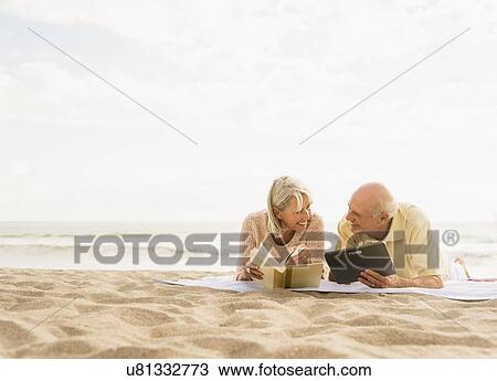Senior couple reading books on beach View Large Photo Image Stock Image - Senior couple reading books on beach. Fotosearch