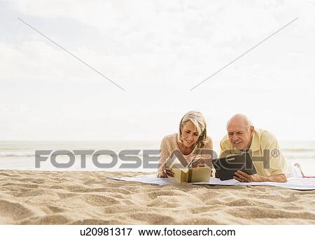 Senior couple reading books on beach View Large Photo Image Stock Photo - Senior couple reading books on beach. Fotosearch