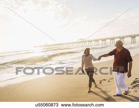 Senior couple walking on beach View Large Photo Image Stock Image - Senior couple walking on beach. Fotosearch