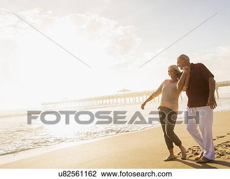Senior couple walking on beach View Large Photo Image Stock Image - Senior couple walking on beach. Fotosearch