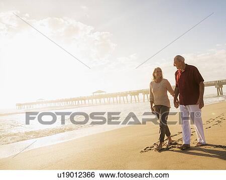 Senior couple walking on beach View Large Photo Image Stock Photograph - Senior couple walking on beach. Fotosearch