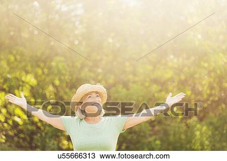 Senior woman in park with arms outstretched View Large Photo Image Stock Image - Senior woman in park with arms outstretched. Fotosearch