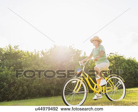 Stock Image - Senior woman on bike. Fotosearch