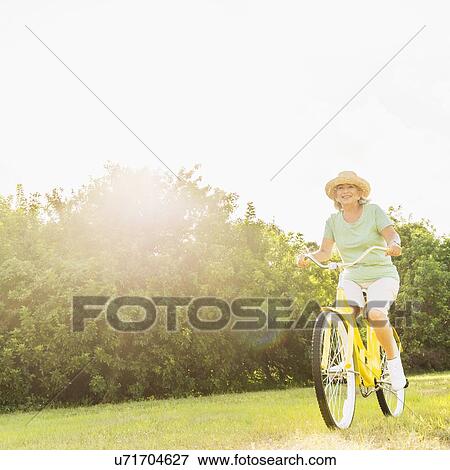 Stock Photo - Senior woman on bike. Fotosearch