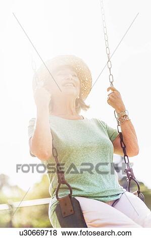 Senior woman on swing View Large Photo Image Stock Photo - Senior woman on swing. Fotosearch