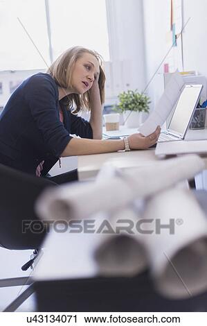 Stock Image - Side view of business woman in office. Fotosearch