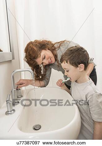 son (6-7) and mother brushing teeth View Large Photo Image Stock Photo - son (6-7) and mother brushing teeth. Fotosearch