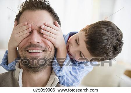 Son (8-9) covering father's eyes View Large Photo Image Stock Photograph - Son (8-9) covering father's eyes. Fotosearch