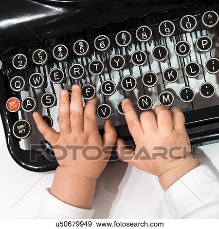 Stock Photo - Studio shot of babies(6-11 months) hand touching typewriter. Fotosearch