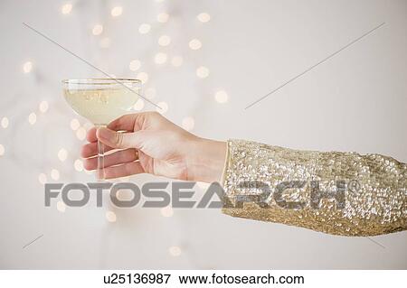 Studio Shot of female's hand holding champagne View Large Photo Image Stock Photo - Studio Shot of female's hand holding champagne . Fotosearch