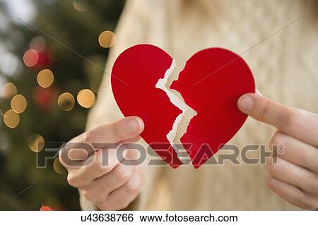 Stock Photograph - Studio Shot of female's hands holding broken heart. Fotosearch