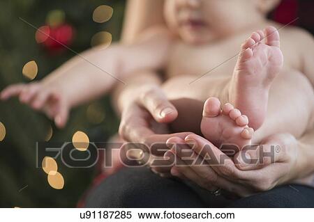 Stock Photography - Studio Shot of mother holding baby girl (6-11 months). Fotosearch