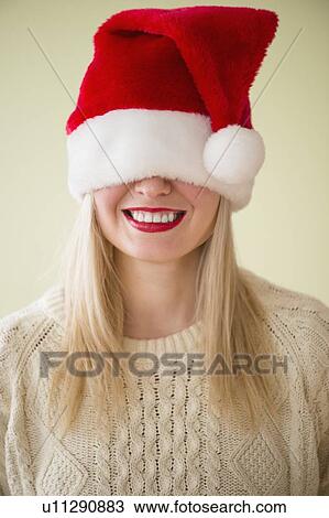 Studio Shot of woman wearing santa hat smiling View Large Photo Image Stock Image - Studio Shot of woman wearing santa hat smiling. Fotosearch