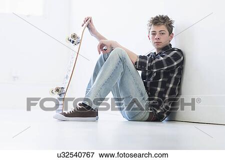 Teenage boy (16-17) holding skateboard View Large Photo Image Stock Photo - Teenage boy (16-17) holding skateboard. Fotosearch