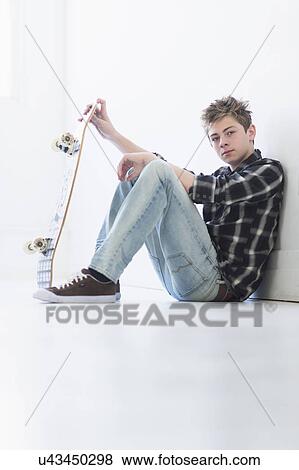 Teenage boy (16-17) holding skateboard View Large Photo Image Stock Photo - Teenage boy (16-17) holding skateboard. Fotosearch