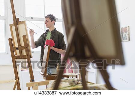 Stock Photo - Teenage boy (16-17) painting picture. Fotosearch