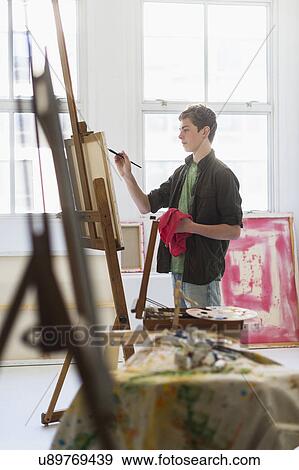 Teenage boy (16-17) painting picture View Large Photo Image Stock Photo - Teenage boy (16-17) painting picture. Fotosearch