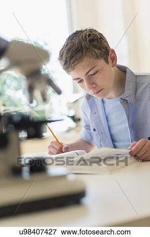 Teenage boy (16-17) reading book in laboratory View Large Photo Image Stock Photo - Teenage boy (16-17) reading book in laboratory. Fotosearch