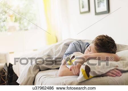 Teenage boy (16-17) sleeping in bed View Large Photo Image Stock Photograph - Teenage boy (16-17) sleeping in bed. Fotosearch