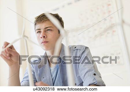 Teenage boy (16-17) touching wind turbines models View Large Photo Image Stock Photo - Teenage boy (16-17) touching wind turbines models. Fotosearch