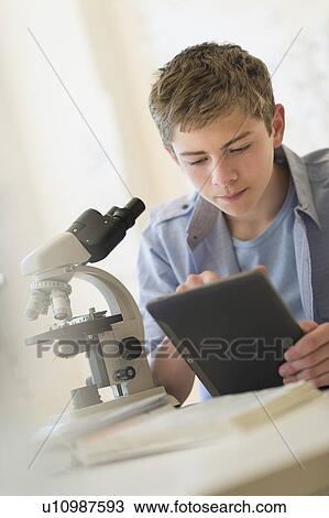 Teenage boy (16-17) using digital tablet in laboratory View Large Photo Image Stock Image - Teenage boy (16-17) using digital tablet in laboratory. Fotosearch