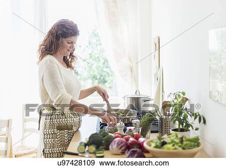 Woman cooking in kitchen View Large Photo Image Stock Photo - Woman cooking in kitchen. Fotosearch