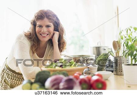 Stock Photograph - Woman cooking in kitchen. Fotosearch