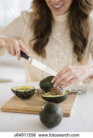 Woman cutting avocados View Large Photo Image Stock Photograph - Woman cutting avocados. Fotosearch