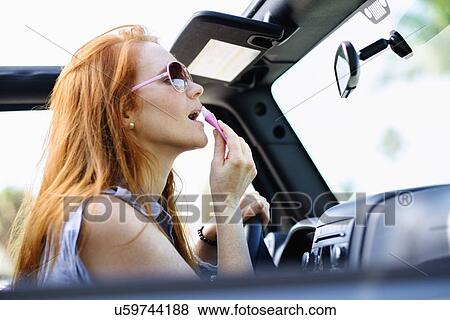 Woman doing make up in car View Large Photo Image Stock Photo - Woman doing make up in car. Fotosearch