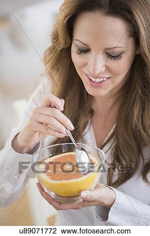 Woman eating grapefruit View Large Photo Image Stock Image - Woman eating grapefruit. Fotosearch