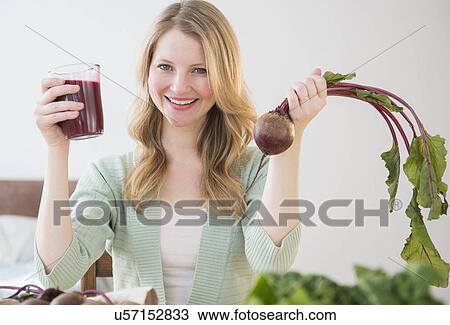 Stock Image - Woman holding beetroot and juice. Fotosearch