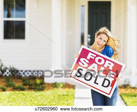 Stock Image - Woman holding for sale sign. Fotosearch