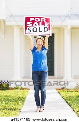 Stock Photography - Woman holding for sale sign. Fotosearch