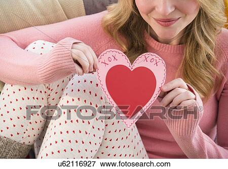 Stock Photo - Woman holding heart shape valentine's card. Fotosearch