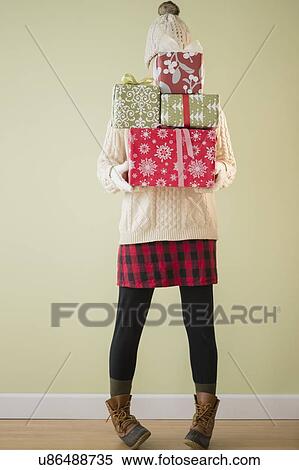 Stock Photography - Woman holding stack of presents. Fotosearch