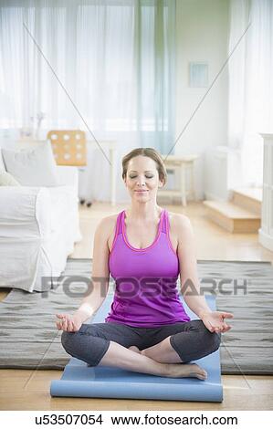 Picture - Woman meditaing at home. Fotosearch