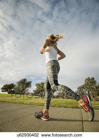 Stock Image - Woman running in park. Fotosearch