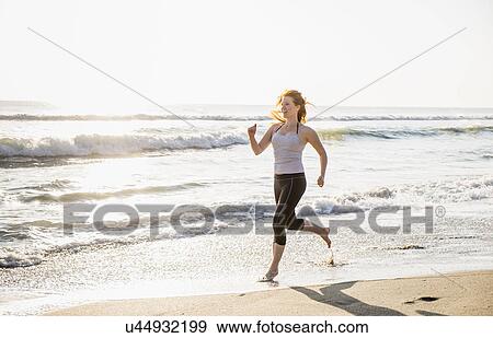 Stock Photo - Woman running on beach. Fotosearch